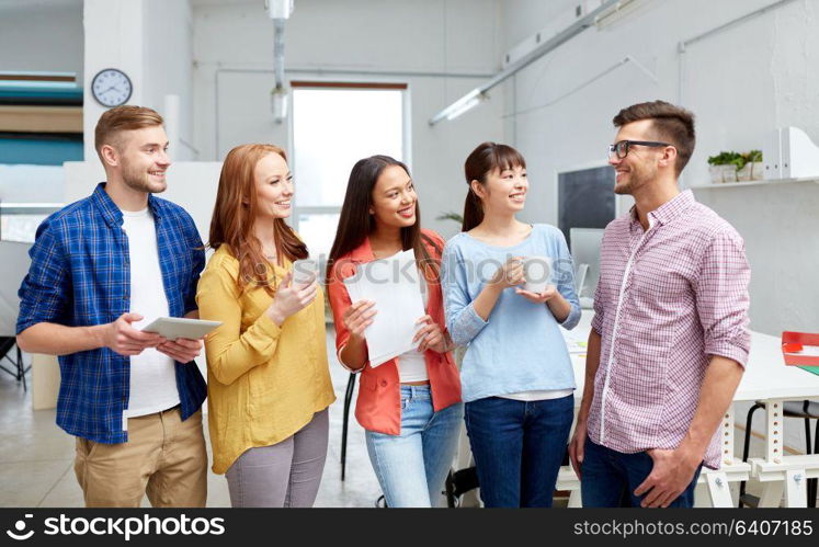 business, startup and people concept - happy international creative team or students drinking coffee at office. happy creative team drinking coffee at office