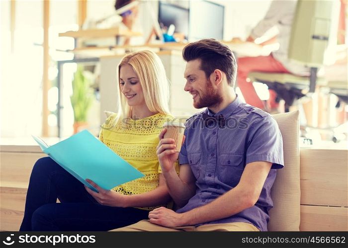 business, startup and people concept - happy man and woman with folder drinking coffee in office