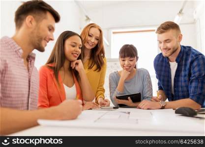 business, startup, architecture and people concept - happy international creative architect team or students with blueprint working at office. creative team with blueprint working at office