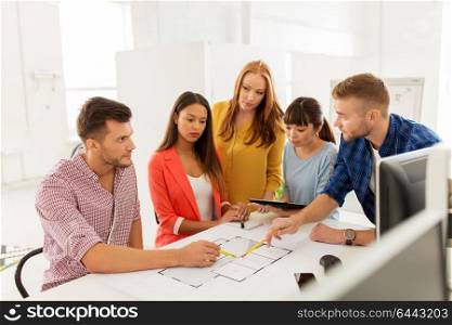 business, startup, architecture and people concept - happy international creative architect team or students with blueprint and tablet pc computer working at office. creative team with blueprint working at office