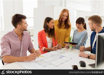 business, startup, architecture and people concept - happy international creative architect team or students with blueprint and tablet pc computer working at office. creative team with blueprint working at office. creative team with blueprint working at office