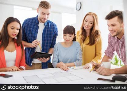 business, startup, education and people concept - creative architect team or students with blueprint working at office. creative team with blueprint working at office