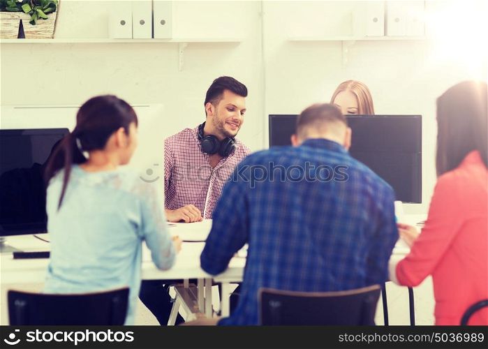 business, startup, education and people concept - happy creative team or students working at office. happy creative team or students working at office