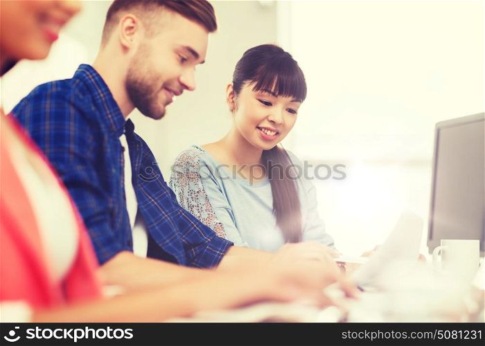 business, startup, education and people concept - happy creative team or students working at office. happy creative team or students working at office