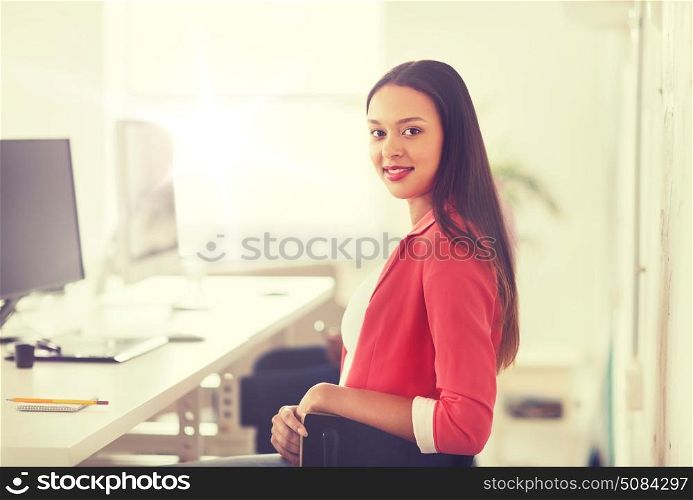 business, startup, education and people concept - happy young african woman with computer working at office. happy african woman with computer at office. happy african woman with computer at office