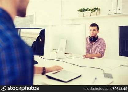 business, startup, education, technology and people concept - happy creative man or student with headphones and computer at office. creative man with headphones and computer. creative man with headphones and computer