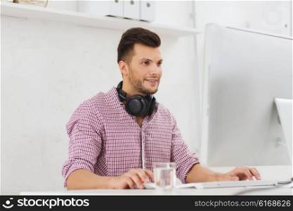 business, startup, education, technology and people concept - happy creative man or student with headphones and computer at office