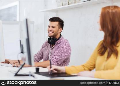 business, startup, education, technology and people concept - happy creative team or students with headphones and computer at office