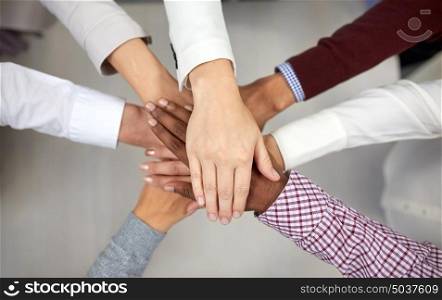 business, startup, gesture, people and teamwork concept - creative team with hands on top of each other at office. business team with hands on top at office