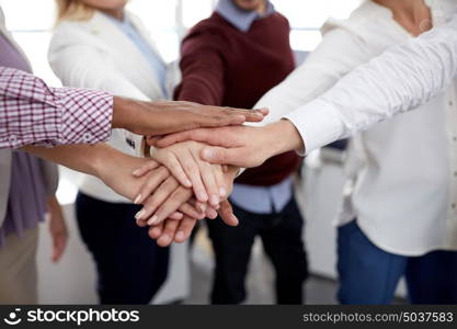 business, startup, gesture, people and teamwork concept - happy creative team with hands on top of each other at office. happy business team with hands on top at office