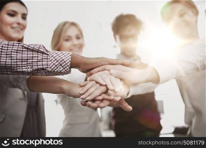 business, startup, gesture, people and teamwork concept - happy creative team with hands on top of each other at office. happy business team with hands on top at office