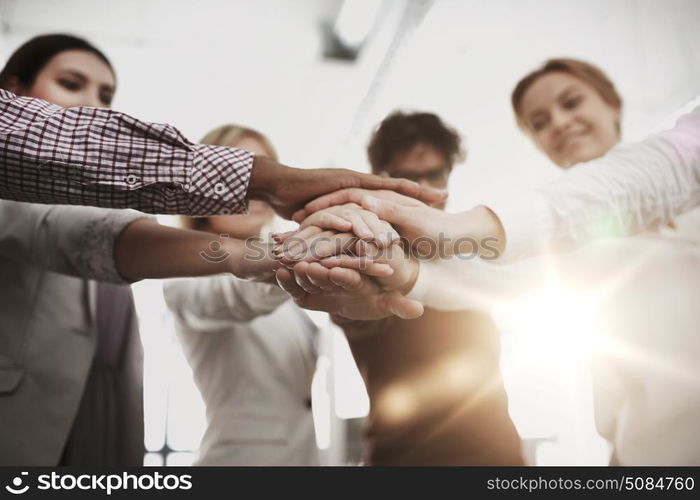 business, startup, gesture, people and teamwork concept - happy creative team with hands on top of each other at office. happy business team with hands on top at office. happy business team with hands on top at office