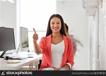 business, startup, gesture, success and people concept - happy young african woman with computer working at office showing thumbs up
