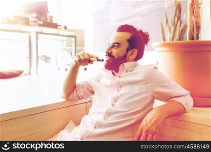business, startup, inspiration and people concept - happy latin man with beard and hair bun at office