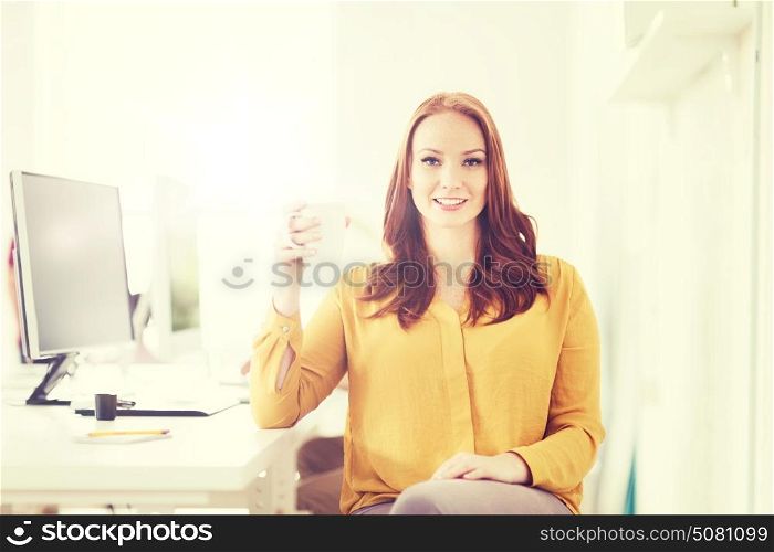 business, startup, people and break concept - happy businesswoman drinking coffee or tea at office. happy woman drinking coffee or tea at office