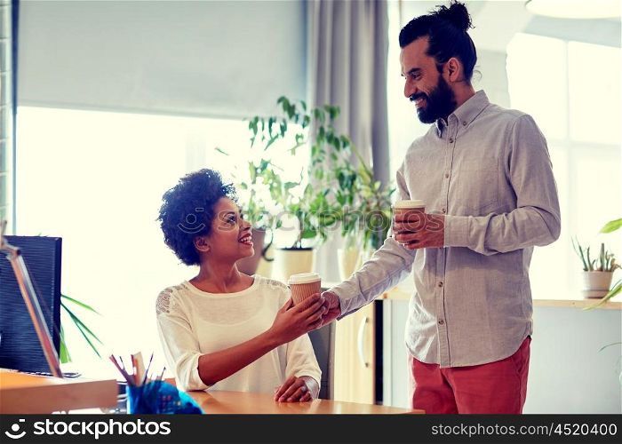 business, startup, people and drinks concept - happy latin man bringing coffee to african woman in office