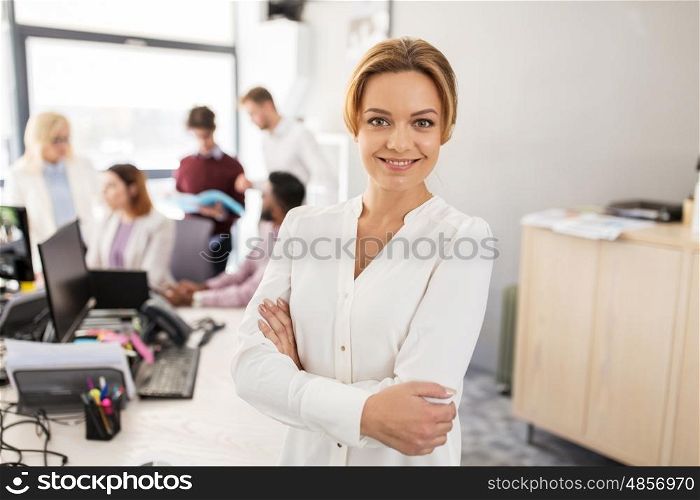 business, startup, people and teamwork concept - happy woman over creative team in office