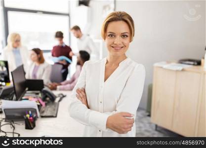 business, startup, people and teamwork concept - happy woman over creative team in office