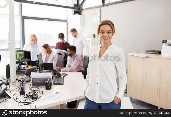 business, startup, people and teamwork concept - happy woman over creative team in office. happy young woman over creative team in office. happy young woman over creative team in office