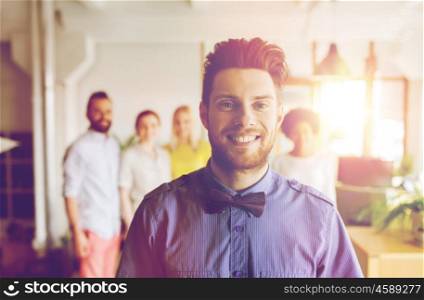business, startup, people and teamwork concept - happy young man with beard over creative team in office