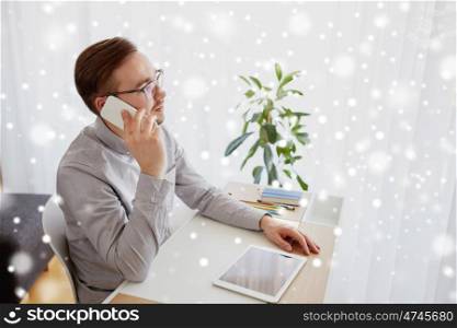 business, startup, technology, communication and people concept - businessman or creative male worker with computer calling on smarphone at home office over snow