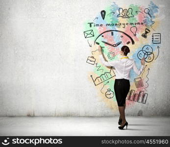 Business strategy and planning . Back view of businesswoman standing on ladder and drawing sketches on wall