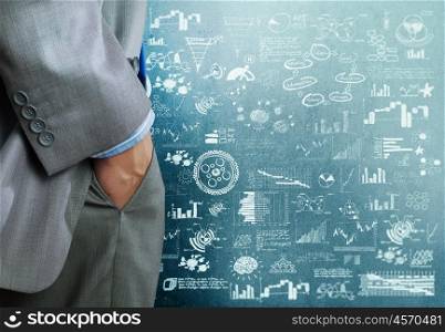 Business strategy. Bottom view of businessman and business strategy sketches on wall
