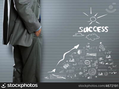 Business strategy. Bottom view of businessman and business strategy sketches on wall