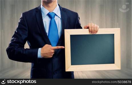 Business strategy. Close up of businessman holding blank frame. Place for text
