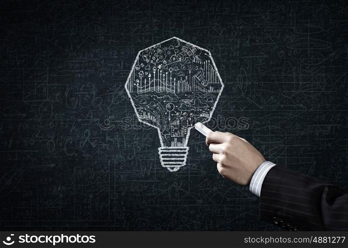 Business strategy. Close up of hand drawing light bulb with chalk