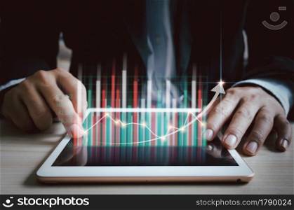business strategy Finance and digital marketing.Businessman using tablet to analyze sales data and economic growth chart.