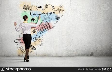 Business strategy planning. Back view of elegant businesswoman drawing sketch on wall