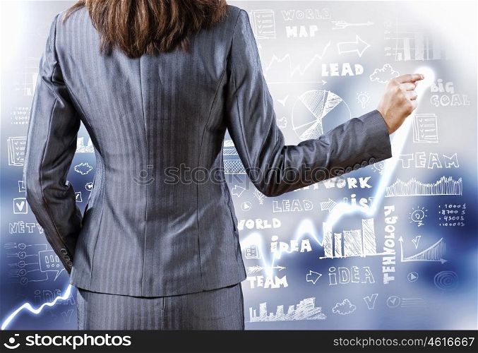 Business strategy. Rear view of businesswoman drawing on digital screen