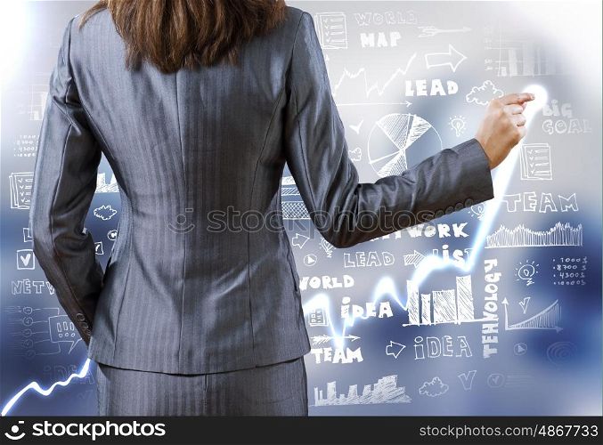 Business strategy. Rear view of businesswoman drawing on screen with finger