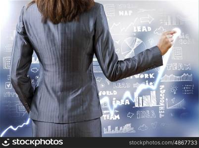 Business strategy. Rear view of businesswoman drawing on screen with finger