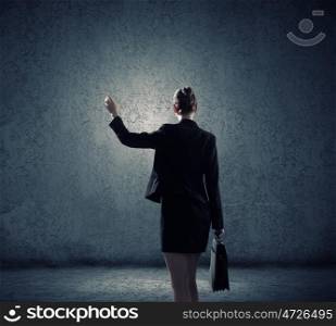 Business strategy. Rear view of businesswoman looking at blank cement wall