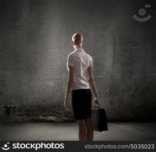 Business strategy. Rear view of businesswoman looking at blank cement wall