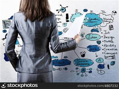 Business strategy. Rear view of businesswoman with papers in hand