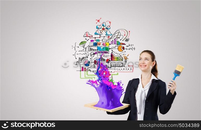 Business strategy. Young businesswoman with paint brush and wooden frame