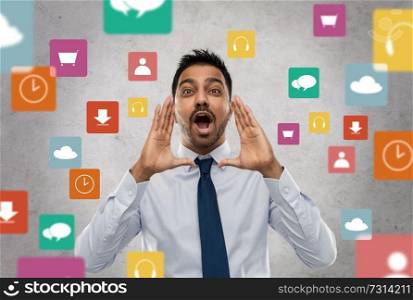 business, stress and people concept - indian businessman shouting or calling over app icons on grey background. indian businessman shouting over app icons
