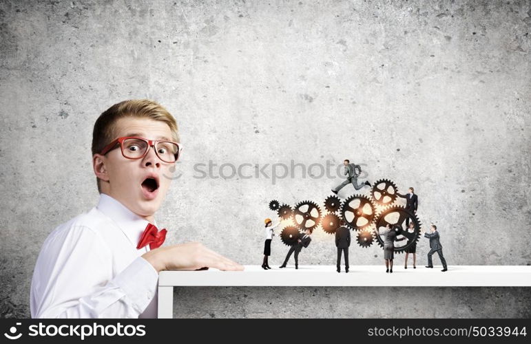 Business structure. Businessman looking from under the table at businessteam