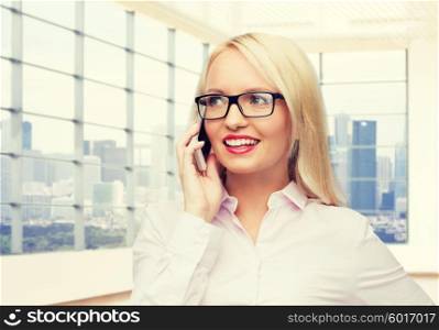 business, style and people concept - smiling businesswoman, student or secretary in eyeglasses calling on smartphone over office window with city view background