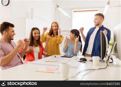 business, success and people concept - happy creative team celebrating victory at office. happy creative team celebrating success at office