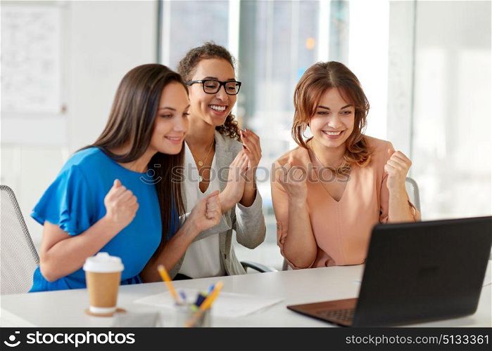 business, success and people concept - happy female team or businesswomen with laptop computer celebrating victory at office. happy businesswomen with laptop at office. happy businesswomen with laptop at office
