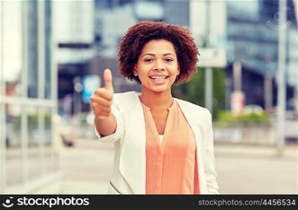 business, success, gesture and people concept - young smiling african american businesswoman showing thumbs uo in city