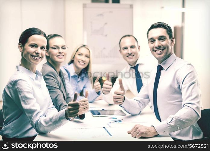 business, success, technology and office concept - smiling business team with tablet pc computer and papers showing thumbs up in office
