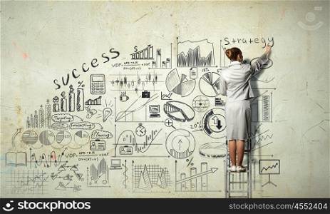 Business successful strategy. Back view of businesswoman standing on ladder and drawing her great plan on wall
