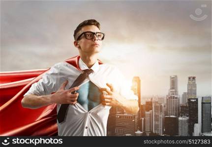 Business super hero. Business superhero. Young businessman showing super hero suit under his shirt down town on sunset.