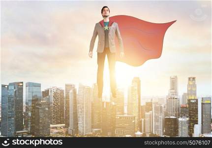Business super hero hover over city skyline. Business superhero. Businessman hovering over down town on sunset.
