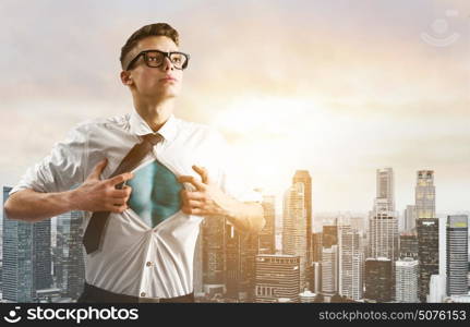 Business super hero hover over city skyline. Business superhero. Young businessman showing super hero suit under his shirt down town on sunset.